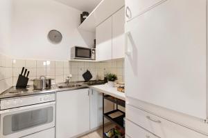 a white kitchen with white cabinets and a sink at Residenza Tasso Sul Lago - Happy Rentals in Ruvigliana