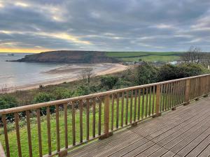 a wooden deck with a view of a beach at Finest Retreats - Beach Cove in Hodgeston +7 photos