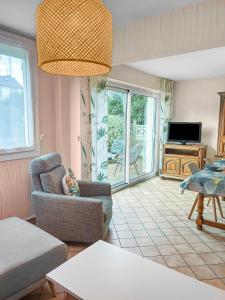 a living room with a chair and a television at Maison familiale à 500m des plages avec jardin in Saint-Nazaire +36 photos