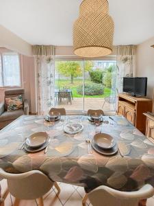 a living room with a table with chairs and a dining room at Maison familiale à 500m des plages avec jardin in Saint-Nazaire