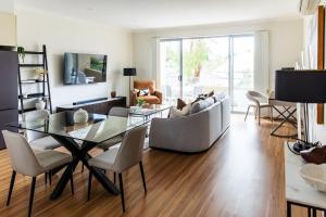 una sala de estar con una mesa y un sofá en Harvey a Stylish and Spacious Retreat in a Prime Location, en Ringwood