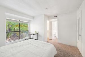 a white bedroom with a bed and a window at Northcliffe 407 I Fully Furnished 2 Bedroom 2bth in Winston-Salem