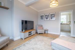 a living room with a flat screen tv and a couch at Westlea House in Airdrie