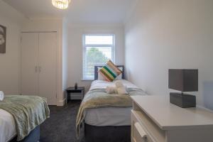 a bedroom with two beds and a flat screen tv at Westlea House in Airdrie