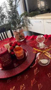 a red table with a plate of food on a table at Ela guest house in Vlorë +4 photos