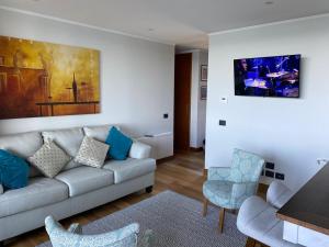 ein Wohnzimmer mit einer Couch und einem Tisch und Stühlen in der Unterkunft Departamento Nuevo en Condominio La Puntilla Villarrica in Villarrica
