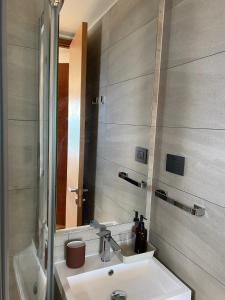 ein Badezimmer mit Waschbecken und Spiegel in der Unterkunft Departamento Nuevo en Condominio La Puntilla Villarrica in Villarrica + 22 Fotos