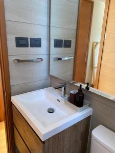 ein Badezimmer mit Waschbecken und Spiegel in der Unterkunft Departamento Nuevo en Condominio La Puntilla Villarrica in Villarrica