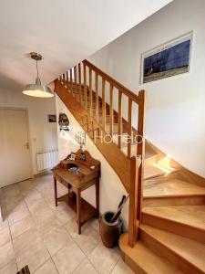 a staircase in a living room with a wooden table at Maison de vacances tout confort - À 100m de la mer in Port-Louis