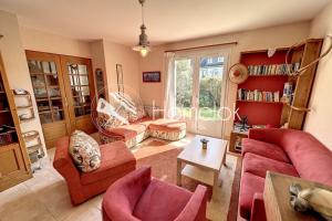 a living room with red furniture and a window at Maison de vacances tout confort - À 100m de la mer in Port-Louis