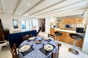 a dining room with a table and a kitchen at Maison de charme Terrasse 5min des plages in Port-Louis