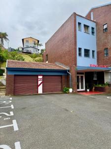 a parking lot in front of a building with a garage at Ridge Royal in Amanzimtoti +2 photos