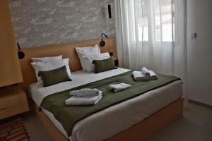 a bedroom with a large bed with towels on it at Hôtel L'Albatros in Saint-Trojan-les-Bains