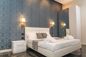 那不勒斯Relais Mermaid Luxury Suite的一间卧室，有两张床和一面蓝色的墙