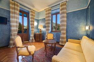a living room with a couch and chairs and windows at Grand Hotel Bellavista Palace & Golf in Montecatini Terme