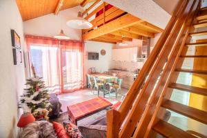 un salon avec une table et une cuisine dans l'établissement Duplex dans chalet avec superbe vue lac et piscine commune, à Gérardmer