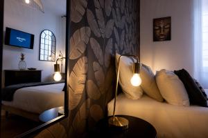 a bedroom with a bed with a headboard and a mirror at Major d'Home Amalgame avec jacuzzi en option in Périgueux
