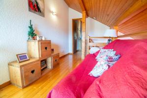 - une chambre avec un lit rose et un plafond en bois dans l'établissement Duplex dans chalet avec superbe vue lac et piscine commune, à Gérardmer 15 autres photos