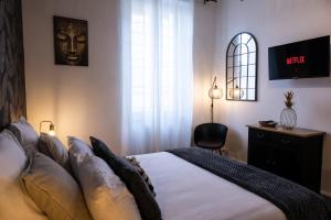 a bedroom with a bed and a desk and a window at Major d'Home Amalgame avec jacuzzi en option in Périgueux +9 photos