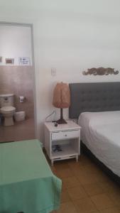 a bedroom with a bed and a lamp on a night stand at casa con piscina aeropuerto flandes in Flandes +37 photos