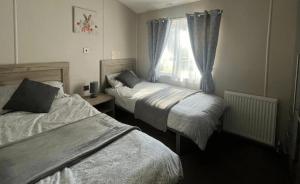 a bedroom with two beds and a window at 1 Bullrush in Tattershall