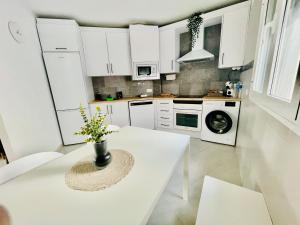 una cucina bianca con tavolo e vaso di Mirador Castillo Belmez a Bélmez