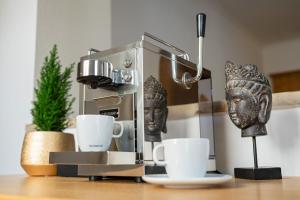 eine Kaffeemaschine und Tassen auf dem Tisch in der Unterkunft ALPHAtauern Health Resort - Adults Only 15 plus in Obertauern