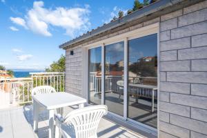 a patio with a table and chairs on a balcony at Il Mare - beach house in Blato +30 photos