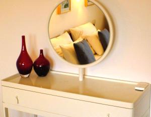 a mirror on top of a dresser with pillows at Solveigs Ferienwohnung in Bad Münstereifel