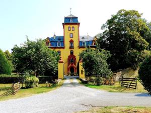 a large yellow house with a tower on top of it at Solveigs Ferienwohnung in Bad Münstereifel