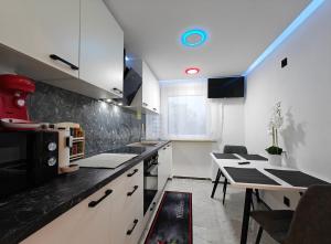 Una cocina con gabinetes blancos y una mesa de comedor. en Modern Apartments Neuburg 9, en Neuburg an der Donau