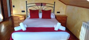 a bedroom with a large bed with red and white pillows at El jardín secreto in Viso