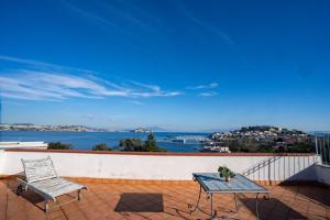 a table and chairs on a balcony with a view of the water at Maison Artista in Procida