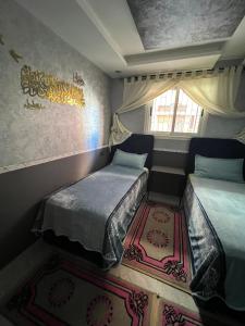 a small room with two beds and a window at Apartment in Safi quartier saida 2 in Safi