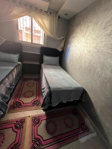 a small room with two beds and a window at Apartment in Safi quartier saida 2 in Safi