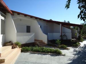 a white house with stairs and plants in a yard at Pansion Comfort Sidro in Novalja