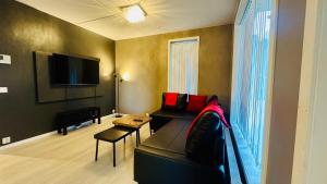 a living room with a black couch and a television at Modern 1BR Flat in Oslo - Central & connected in Oslo