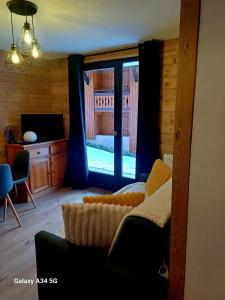 Una sala de estar con un sofá y una ventana grande. en Le Chamois, en Morzine