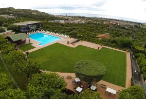 widok na duży trawnik z basenem w obiekcie 'A Nuciara Park Hotel & Spa w mieście Furci Siculo