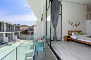 a bedroom and a balcony with a bed and a table at Zen Style Pool Access Townhouse in Nathon Bay +52 photos