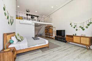 a bedroom with a large bed and a staircase at Zen Style Pool Access Townhouse in Nathon Bay