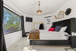 a bedroom with a bed and a large window at Love Shack at Mystic Hills Ranch in Fischer
