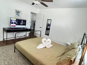 克利尔沃特Beautiful Studio 10 Min From The Beach 1的一间卧室配有一张带两个白色弓的床