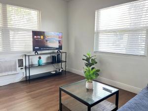 克利尔沃特Beautiful Studio 10 Min From The Beach 1的一间带电视和玻璃桌的客厅 更多3张照片