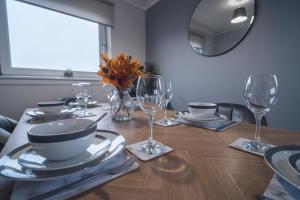 a dining room table with glasses and plates on it at Franklin Place in East Kilbride