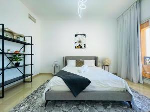 拉斯阿尔卡麦Seabreeze Vacation Homes, Cozy Beach Apartment 1BHK的一间白色墙壁的房间,卧室配有床铺 更多9张照片