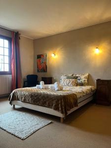 a bedroom with a bed with two towels on it at La Chaumière DE L'EAU SAUVAGE in Villeneuve-sur-Allier