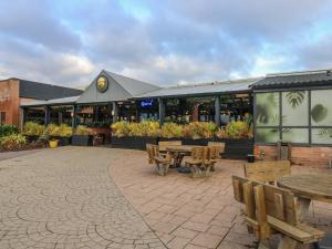 a patio with tables and benches in front of a building at MillRythe Holiday Park Dunlin Walk 13 in North Hayling