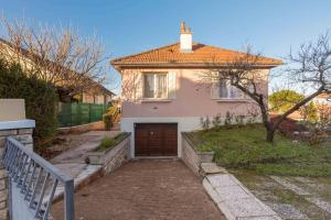 a white house with a brown door and a fence at Sweet Burgundy Villa in Dijon