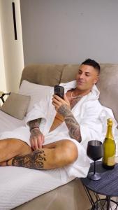 a man laying in bed looking at his cell phone at Luxury apartment - SUITE CAVOUR in Bari